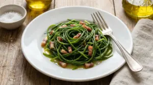 Piatto di barba di frate con cubetti di pancetta e olio d'oliva su un tavolo rustico